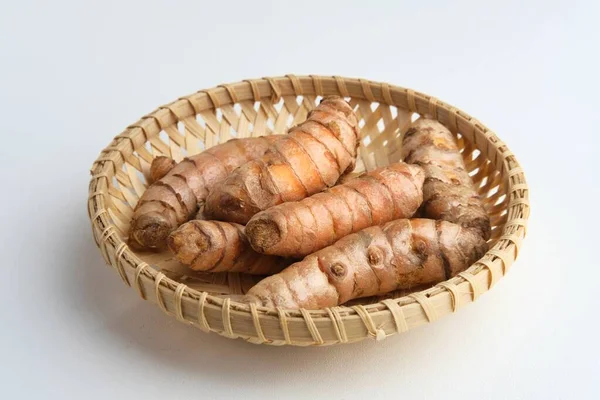 ウコン クルクマ クルクマ ロンガ 根茎は白地に籐籠で供される 多くの健康上の利点を持つハーブ — ストック写真