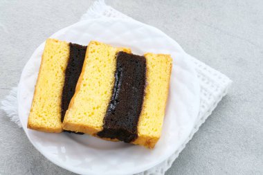 Spiku ya da Lapis Surabaya ya da Surabaya Katmanlı Kek, aralarında çilek reçeli bulunan üç katmanlı bir kek. Beyaz tabakta servis ediliyor, kapat..