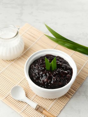 Bubur Ketan Hitam, Endonezya tatlısı. Hindistan cevizi sütü, şeker ve pandan yaprağı ile siyah glutinous pirinç lapası. Bulanık arkaplan ve seçici odak.