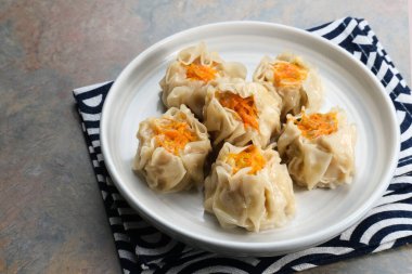 Lezzetli Dim Sum, tabakta servis edilen ev yapımı Çin mantısı, sos ve çubukla. Gri arkaplanda izole edilmiş, kapat.