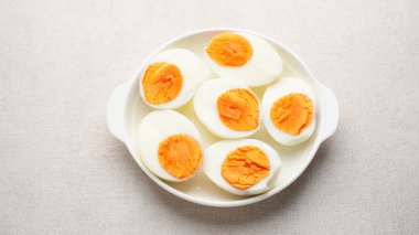 Haşlanmış yumurta kabuğu soyulmuş ve tabakta kesilmiş.
