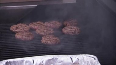 Izgarada pişen hamburgerlerin yakın çekimi.