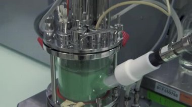 Laboratuvarda yeşil sıvı tutan makinenin eğimi.