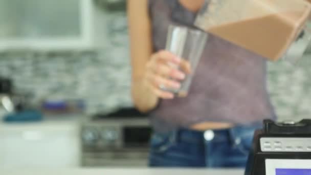 A Tight tilt up with rack focus of woman pouring smoothie out from blender — Vídeo de Stock