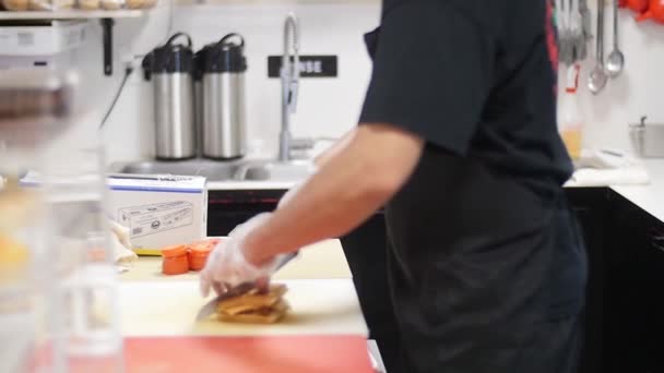En person som står i ett kök och lagar mat — Stockvideo