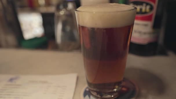 Een close-up van een glas bier op een tafel — Stockvideo