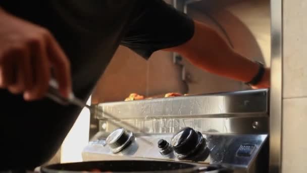 Uma pessoa que cozinha em uma cozinha preparando comida — Vídeo de Stock