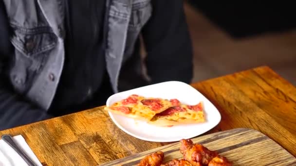 Kawałek pizzy siedzący na drewnianym stole — Wideo stockowe