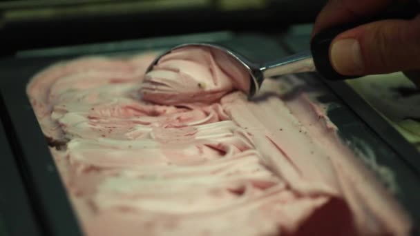 En server som plockar jordgubbssmaksatt gelato från brickan inuti gelatoaletten — Stockvideo