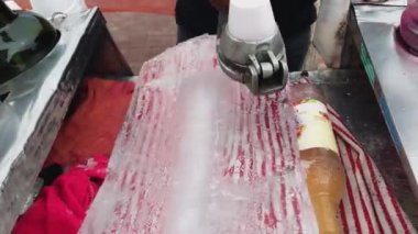 Buz külahı için buz kalıbını traş etmek.