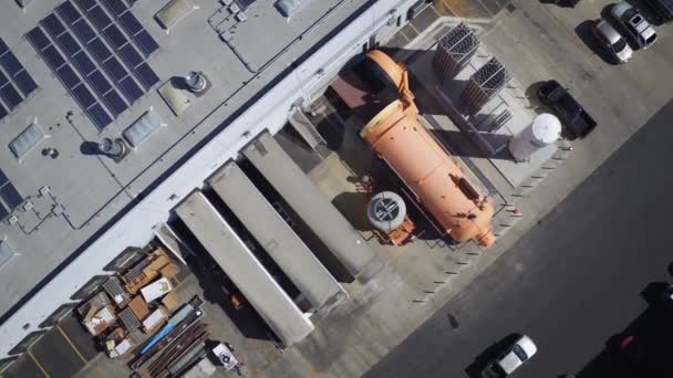 Une vue à vol d'oiseau descendante au-dessus du quai de chargement du bâtiment avec autoclave industriel orange — Video