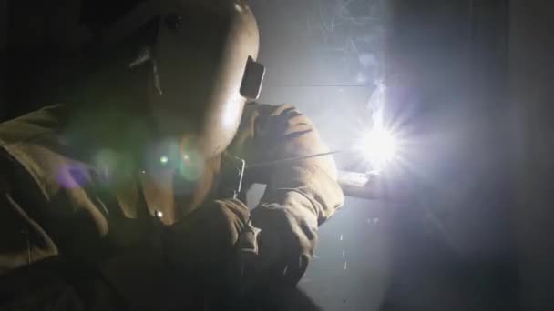 Ένας βιομηχανικός εργάτης σε κράνος συγκόλλησης χρησιμοποιώντας συγκολλητή ράβδων — Αρχείο Βίντεο