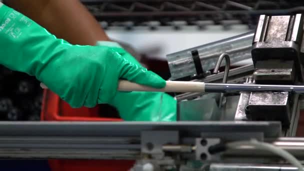 Een fabrieksmedewerker zet grip op gloednieuwe golfclubs in productiefaciliteit slow motion — Stockvideo