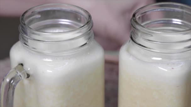 Un tiro apretado de pajitas que se ponen en frasco con batido — Vídeos de Stock