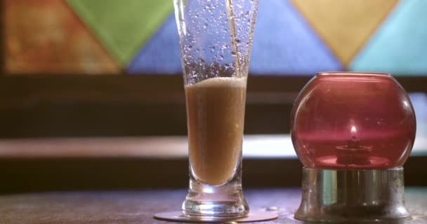 Een glazen fles zittend op een tafel — Stockvideo