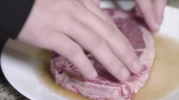 A Tight shot of person pressing steak in seasoning — Stock Video