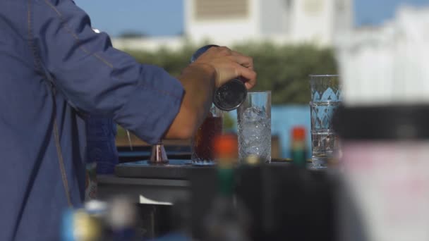 Seorang bartender menuangkan darah menikah ke gelas di sebuah bar luar — Stok Video