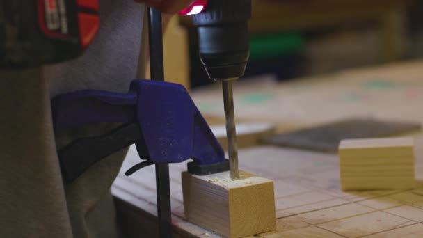 Um Handyman perfuração em bloco de madeira na oficina — Vídeo de Stock