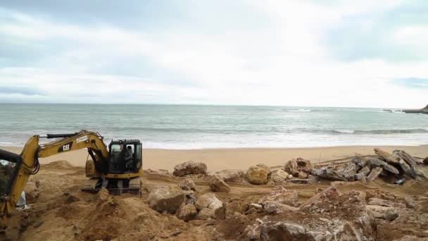 Un tractor en una playa cerca de un cuerpo de agua — Vídeos de Stock