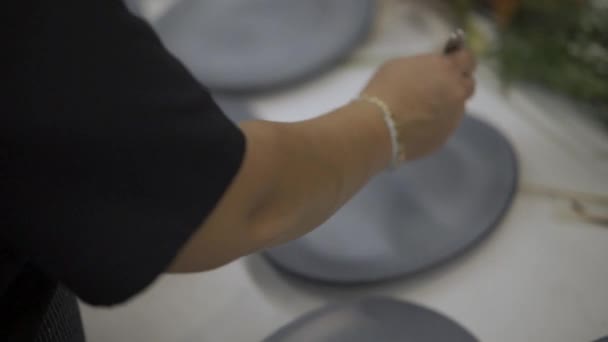 Uma garra de fêmea adicionando deserto sobre pratos na mesa — Vídeo de Stock