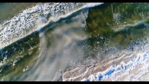 Um tiro de puxar afastado na água batendo gelo na costa da praia — Vídeo de Stock