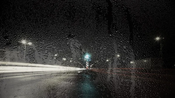 通过玻璃与雨滴的道路的夜景 — 图库照片