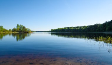 Mavi gökyüzü ve bulutlar yansıtan bahar Orman Gölü