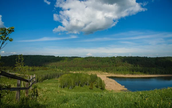 Lago bosque de primavera que refleja el cielo azul y las nubes — Foto de Stock