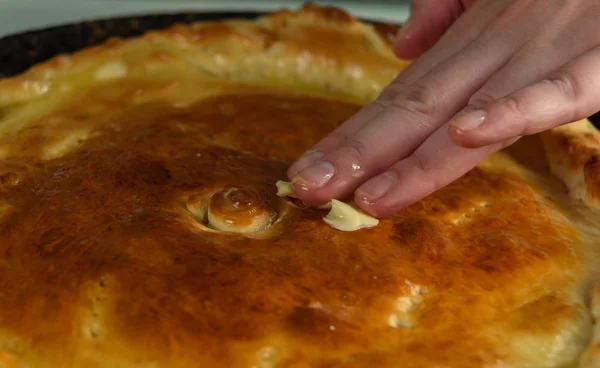 Damskie ręce są plamy oleju gorący rumiany pie — Zdjęcie stockowe