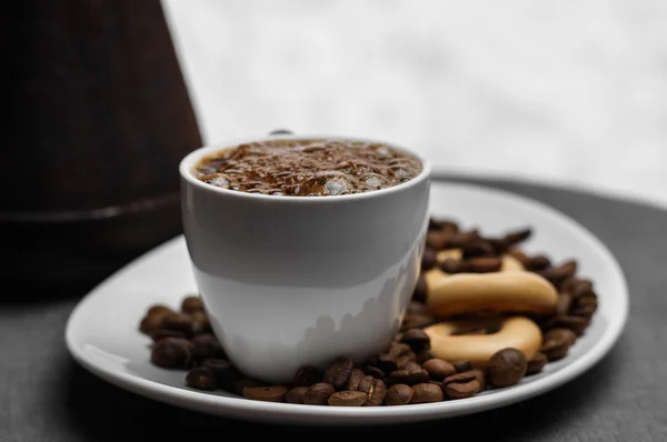 Xícara de café, um turco e grãos em fundo cinza — Fotografia de Stock