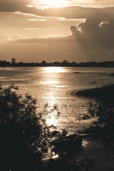 Verão pôr do sol sobre o lago e barco solitário na costa — Fotografia de Stock