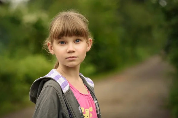 Fille adolescent avec des cheveux blonds dans le fond d'une route rurale — Photo