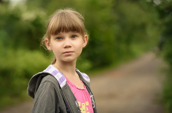 Chica adolescente con pelo rubio en el fondo de un camino rural — Foto de Stock