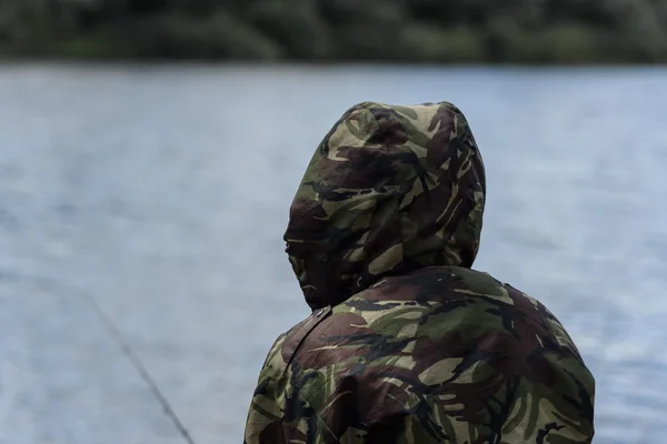 Fisherman with a feeder in front of river — Stock Photo, Image