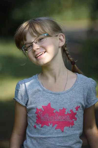 Joyeuse adolescente avec deux queues debout dans le jardin sur fond vert — Photo