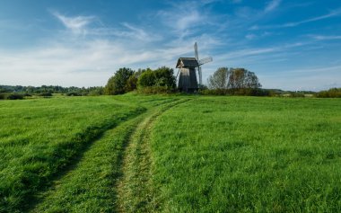 Mavi gökyüzü arka plan beyaz bulutlar ile yeşil alanında yel değirmeni