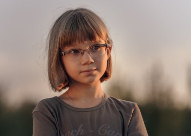 kısa sarı saçları ve mavi gözleri akşam gökyüzü karşı üzgün genç kızla