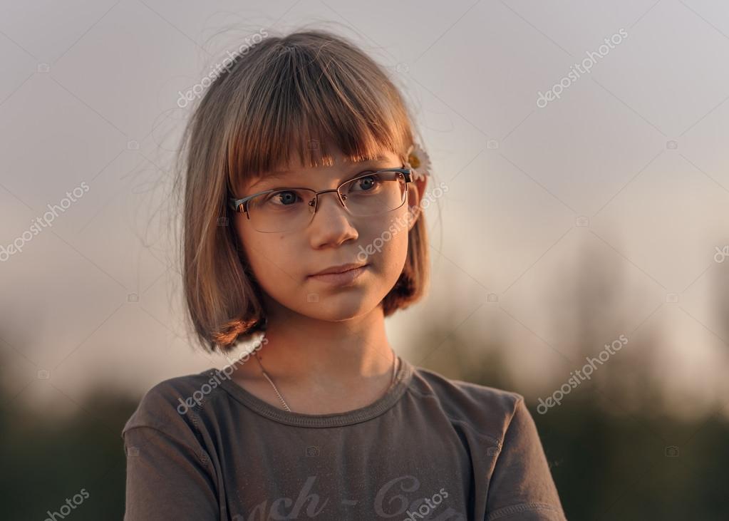 Sad Teenager Girl With Short Blonde Hair And Blue Eyes Against