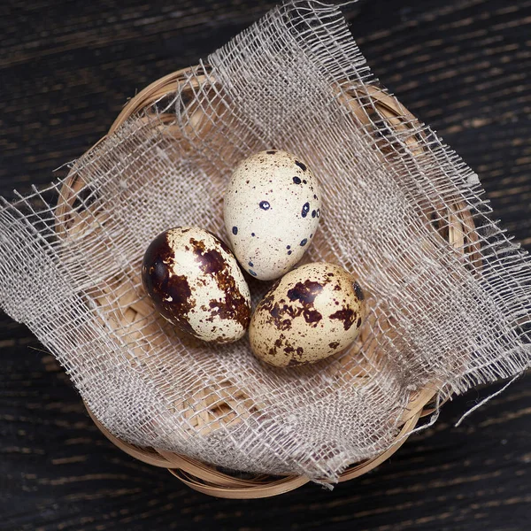 Fresh quail egg on burlap cloth on dark wooden table. — Stock Photo, Image