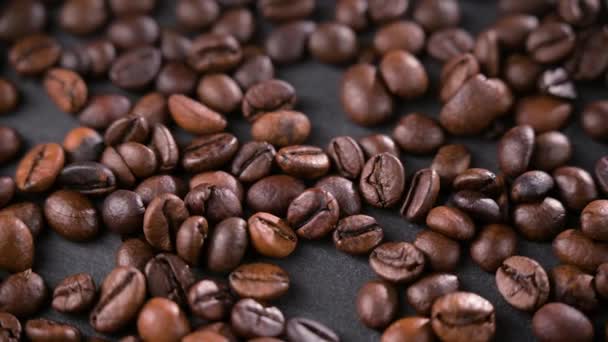 Zbliżenie nasion kawy. Ziarna kawy są rozrzucone na stole. Tło w rozmyciu. — Wideo stockowe