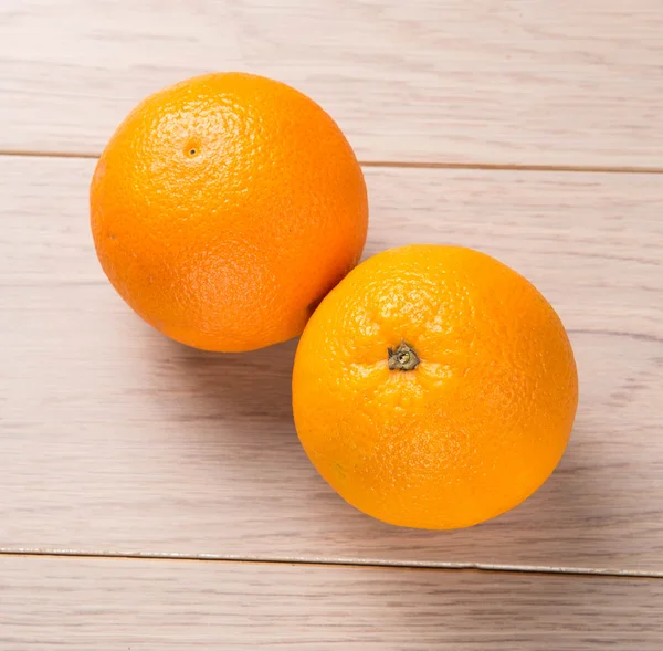 Pomarańczowe owoce na drewnianym stole tło — Zdjęcie stockowe