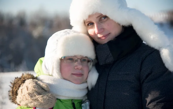 Winter portrait of mother and daughter in white hats Royalty Free Stock Images