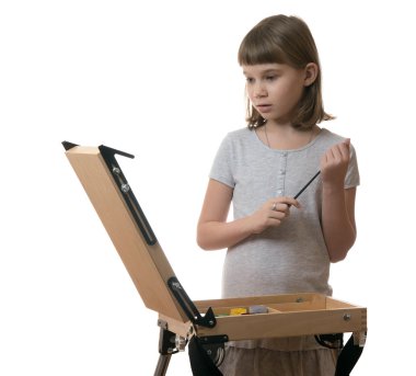 Kız bir tabloya şövale beyaz zemin üzerine çizer.