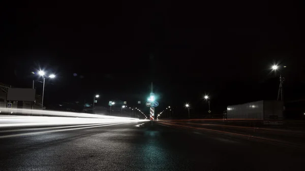 在夜间通过城市移动有灯光的汽车 — 图库照片