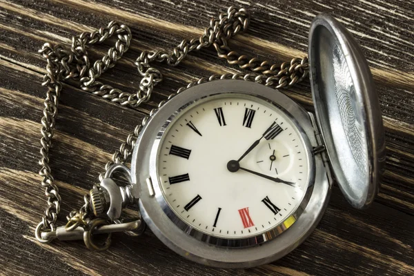 Reloj de bolsillo de plata viejo acostado en una mesa de madera. Vista superior —  Fotos de Stock