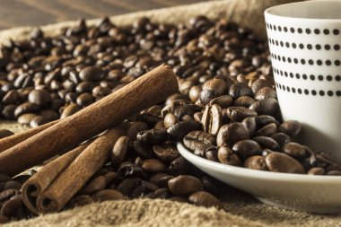 Beyaz kupa kahve çekirdekleri ve tarçın ile polka noktalı.