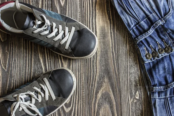 Mavi ayakkabılar ve kot pantolon yalan ahşap kurullarında. Üstten Görünüm