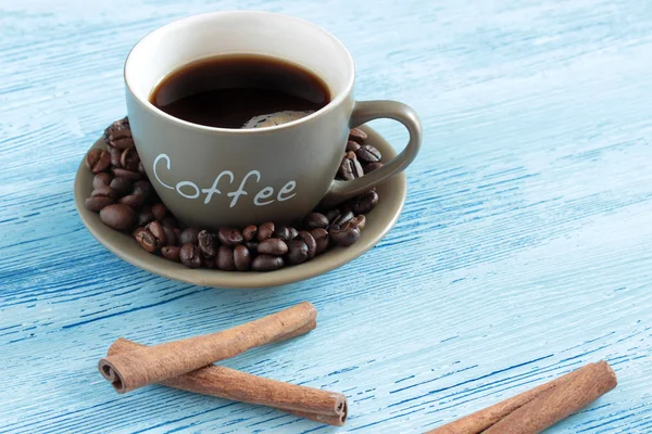 Kahve fasulye ve tarçın ile ahşap bir masa üzerinde sopa — Stok fotoğraf