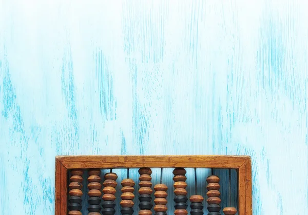 Старый деревянный поцарапанный старинный десятичный счетчик на синей деревянной доске на заднем плане. Вид сверху. Плоский лежал . — стоковое фото