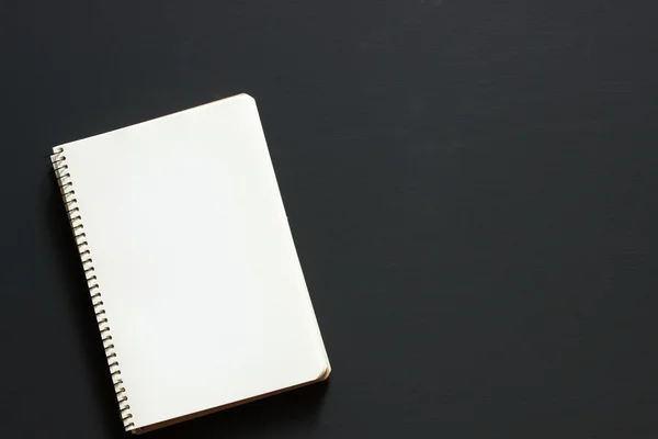 Un simple cahier blanc vide avec un blanc pour dessiner ou écrire se trouve sur un bureau à partir d'un tableau noir. Vue de dessus. Maquette. Pose plate — Photo